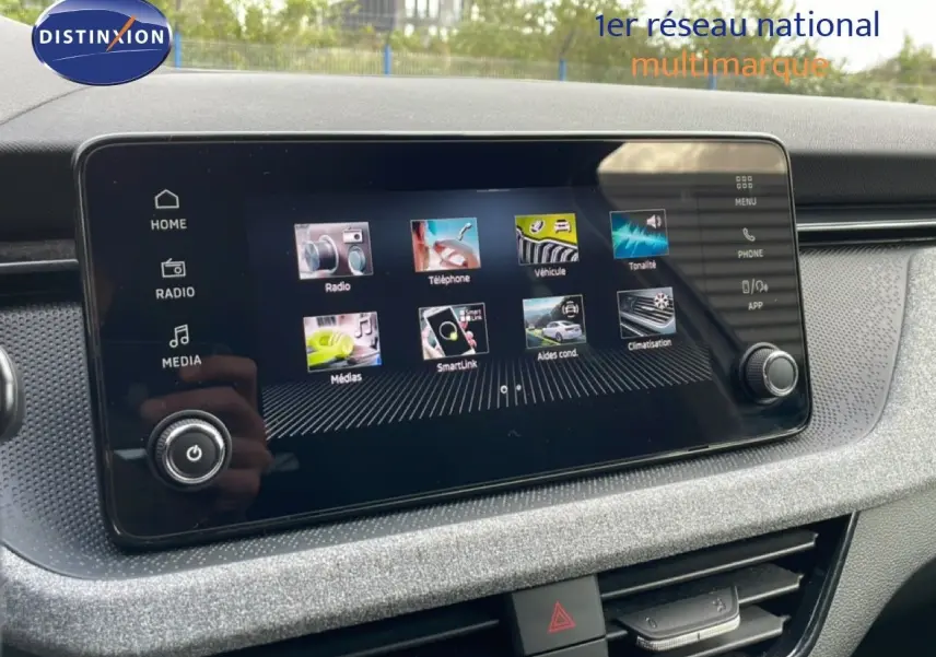 Écran tactile central de la Skoda Scala blanc glacier, vue rapprochée du tableau de bord avec interface multimédia active.
