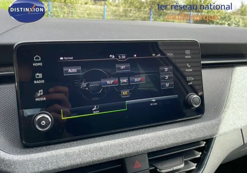 Écran tactile central affichant la climatisation dans l’habitacle gris clair d’une Skoda Scala blanche.
