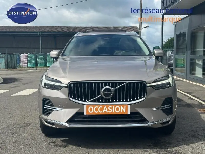 Vue frontale d'un Volvo XC60 gris 2024 avec calandre chromée et plaques "OCCASION" visibles.