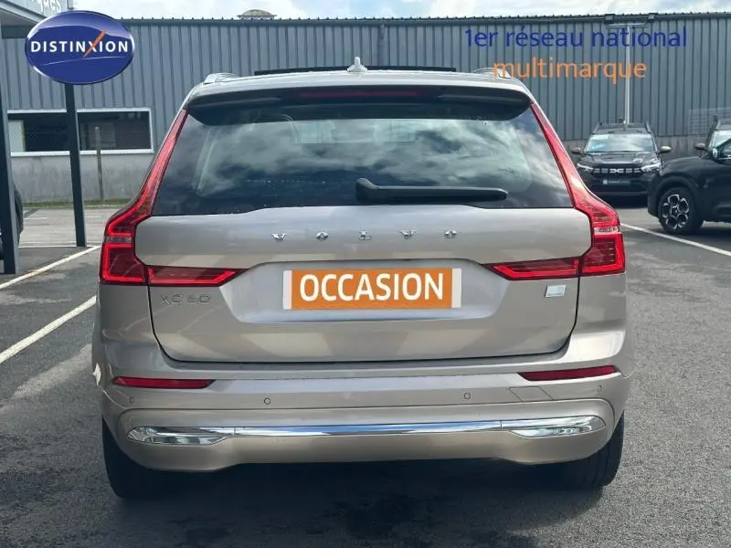 Vue arrière d'un Volvo XC60 gris 2024 avec feux LED en forme de L et plaque "OCCASION" visible.