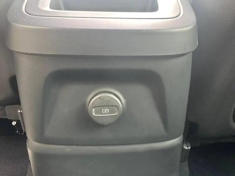 Prise 12V noire vue de face sur la console arrière intérieure d’un Volvo XC60 gris 2024 hybride rechargeable.