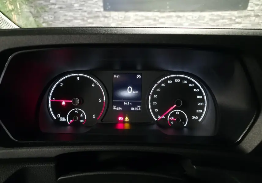Vue rapprochée du combiné d'instruments du Volkswagen Caddy blanc, affichant vitesse, régime et alertes au tableau de bord.