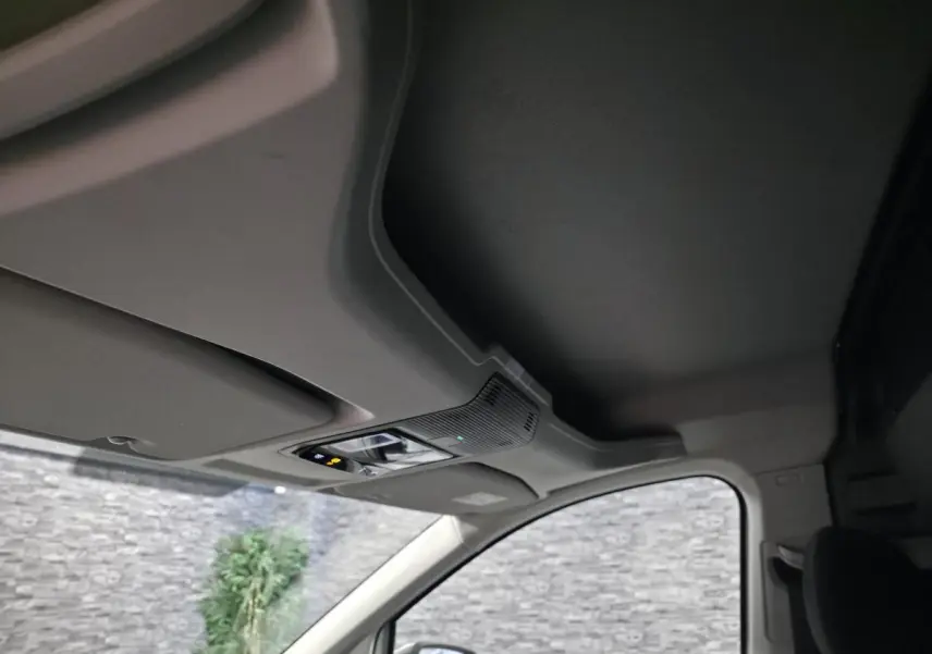 Vue intérieure du plafond et pare-soleil côté conducteur du Volkswagen Caddy Cargo blanc avec commandes d’éclairage intégrées.