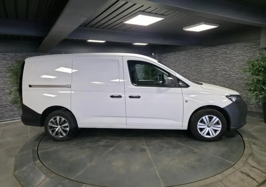 Vue latérale droite d'un Volkswagen Caddy Cargo blanc 2023 avec portes coulissantes et jantes acier.