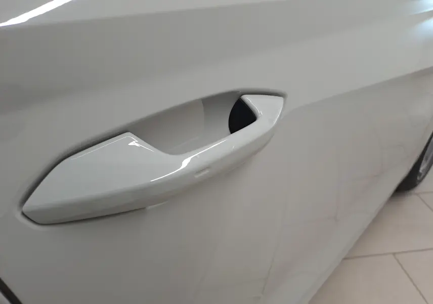 Poignée de porte côté gauche en gros plan sur Skoda Octavia Combi gris perle 2021, finition lisse et intégrée au panneau.