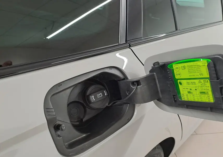 Gros plan sur la trappe à carburant côté gauche d’une Skoda Octavia Combi gris perle avec étiquette verte de pression pneus.