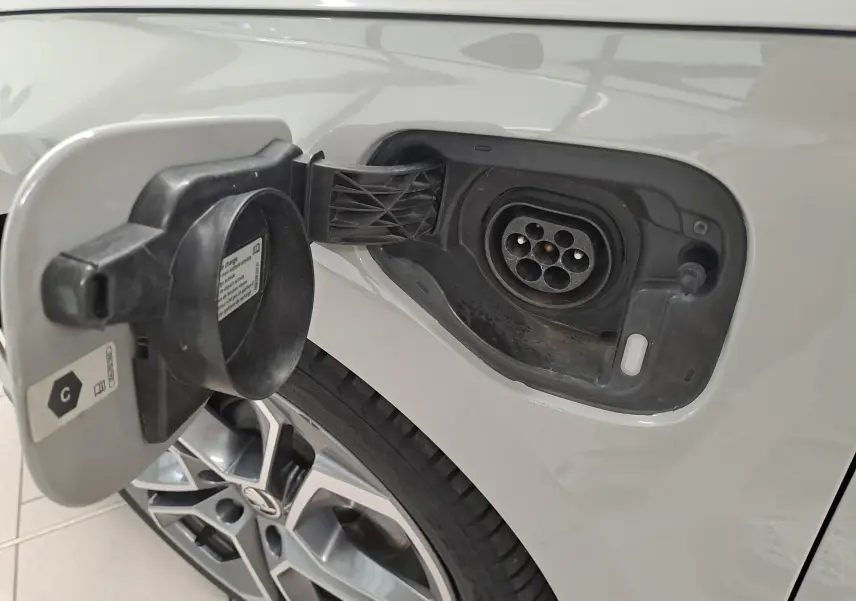 Gros plan sur la trappe de recharge ouverte côté gauche d’une Skoda Octavia Combi gris perle avec jante alliage 19'' anthracite.