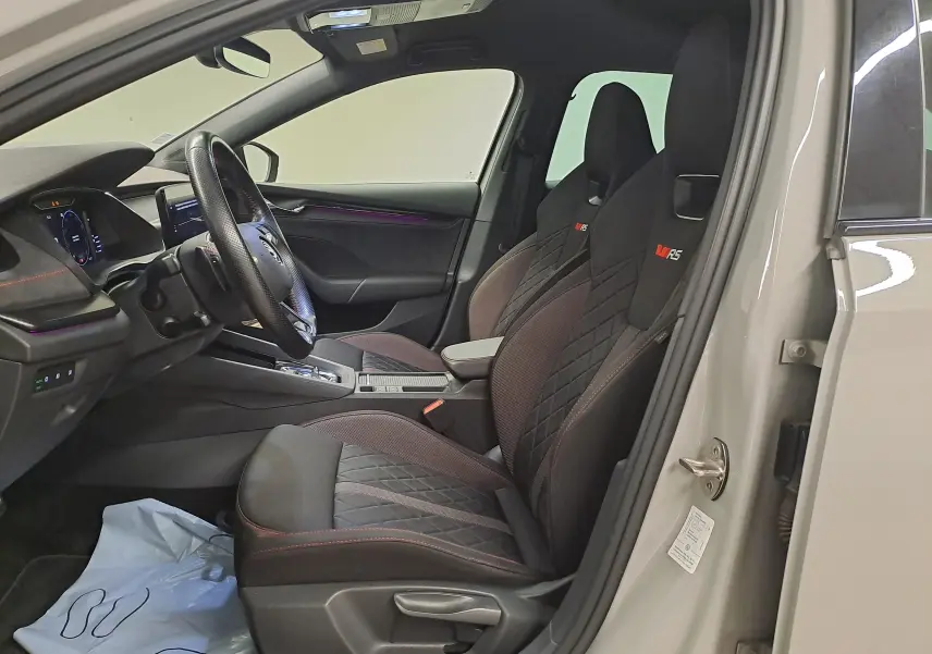 Vue intérieure côté conducteur de la Skoda Octavia Combi gris perle 2021, sièges sport RS avec surpiqûres rouges.