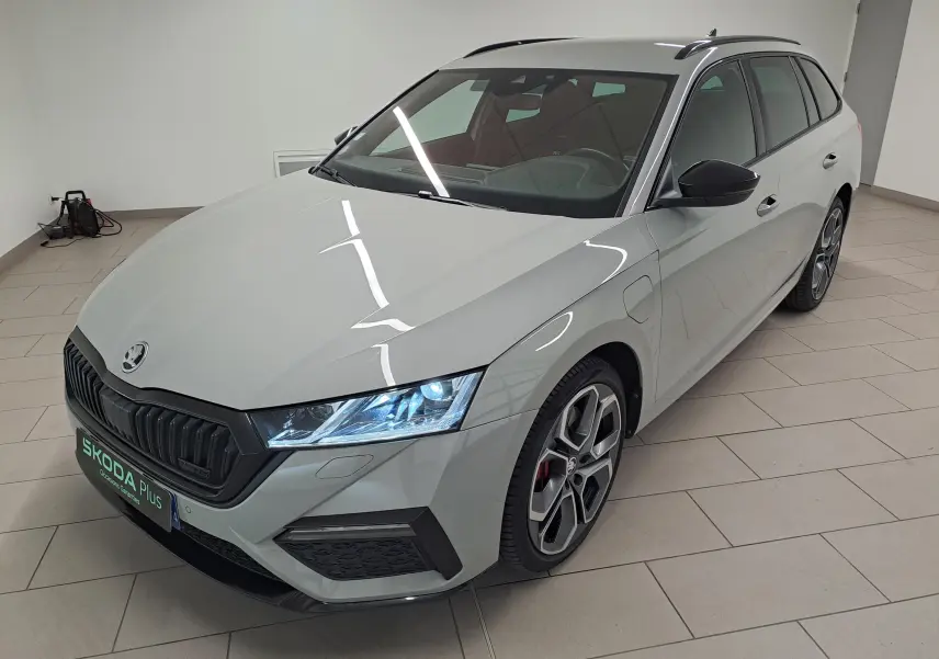 Vue 3/4 avant droite d'une Skoda Octavia Combi gris perle avec jantes alliage 19'' anthracite polies et phares allumés.