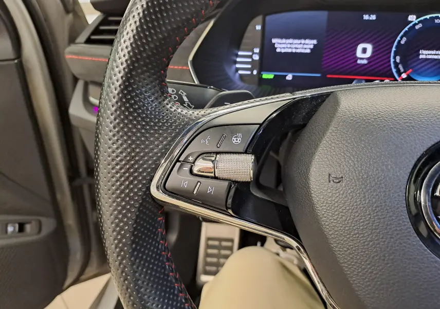 Gros plan sur le volant perforé avec commandes intégrées et tableau de bord numérique de la Skoda Octavia Combi 1.4 TSI PHEV.