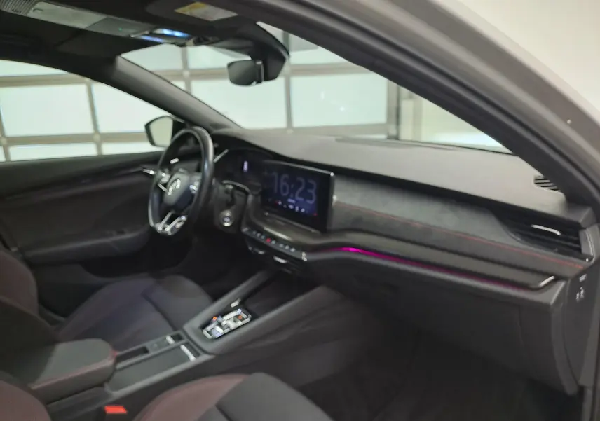 Vue intérieure côté conducteur de la Skoda Octavia Combi 1.4 TSI PHEV 2021 avec tableau de bord noir et éclairage d’ambiance violet.