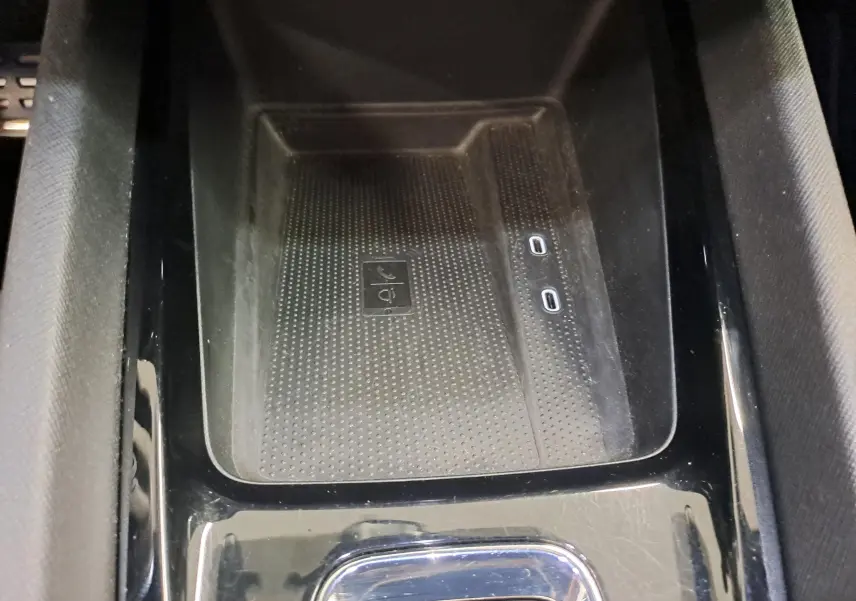 Gros plan sur la console centrale noire avec zone de recharge sans fil et deux ports USB-C dans une Skoda Octavia Combi gris perle.