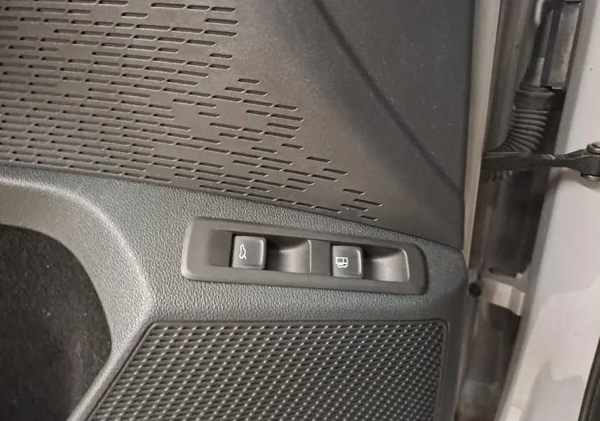 Gros plan sur les boutons d'ouverture du hayon et de la trappe à carburant côté gauche d'une Skoda Octavia Combi gris perle.