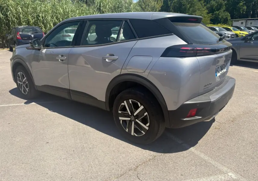Peugeot 2008 Hybrid gris en 3/4 arrière droit, avec jantes 16 pouces et toit noir contrasté.