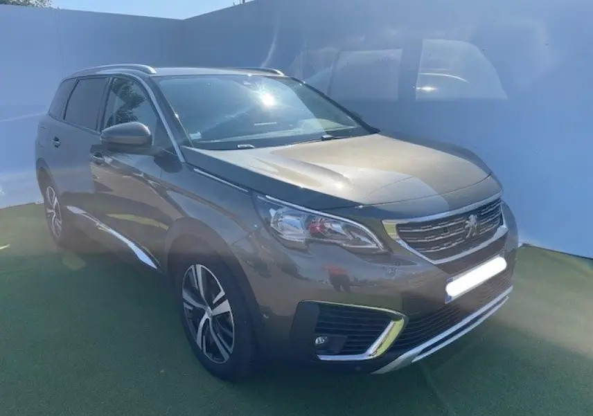 Peugeot 5008 gris amazonite vue 3/4 avant droit, avec calandre chromée et jantes alliage distinctives.