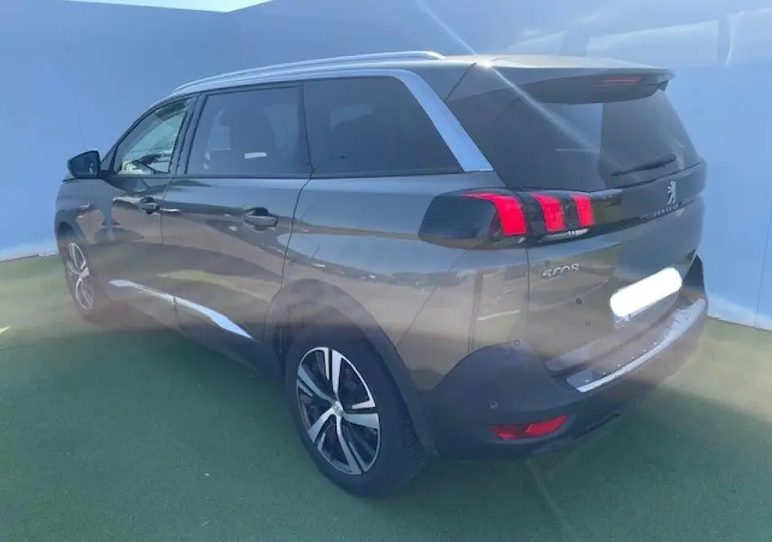 Peugeot 5008 gris amazonite vue 3/4 arrière droit, feux arrière à griffes rouges et jantes alliage visibles