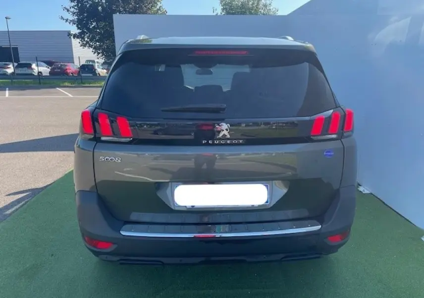 Vue arrière d'un Peugeot 5008 gris Amazonite avec feux arrière à trois griffes rouges et logo lion chromé.
