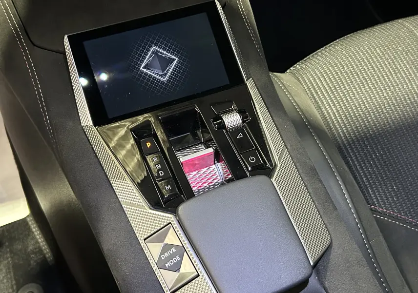 Vue rapprochée de la console centrale du DS4 2024 noir Perla Nera, mettant en valeur la molette de sélection et l'écran tactile.