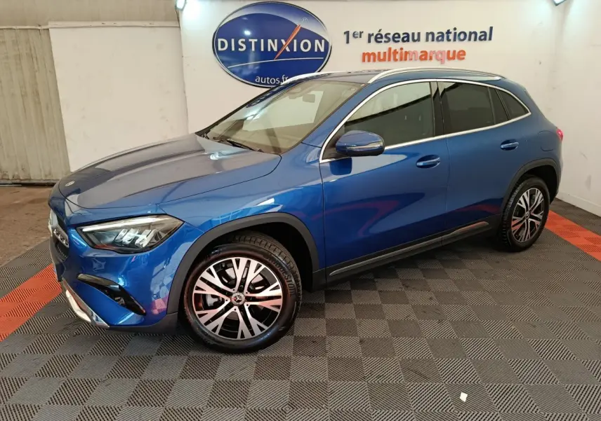 Mercedes GLA 250 e Business Line bleu en 3/4 avant droit, avec jantes alliage et rétroviseurs chromés dans un showroom.