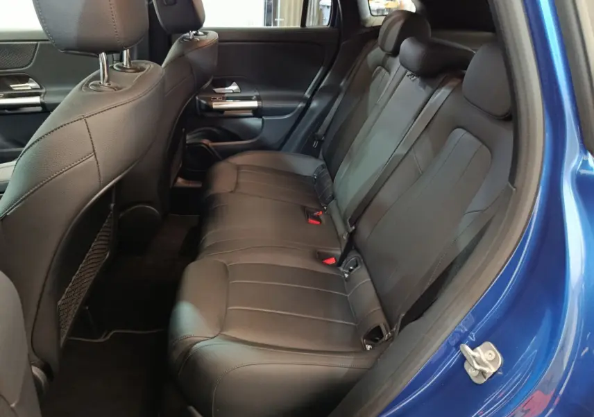 Vue côté droit de l'habitacle arrière d'un Mercedes GLA 250 e bleu avec sièges en cuir noir et ceintures de sécurité.