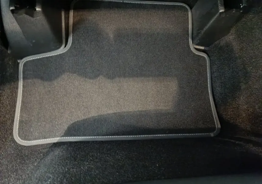 Tapis de sol noir avec surpiqûres blanches dans l'habitacle avant d'une Mercedes GLA 250 e Business Line 2024.