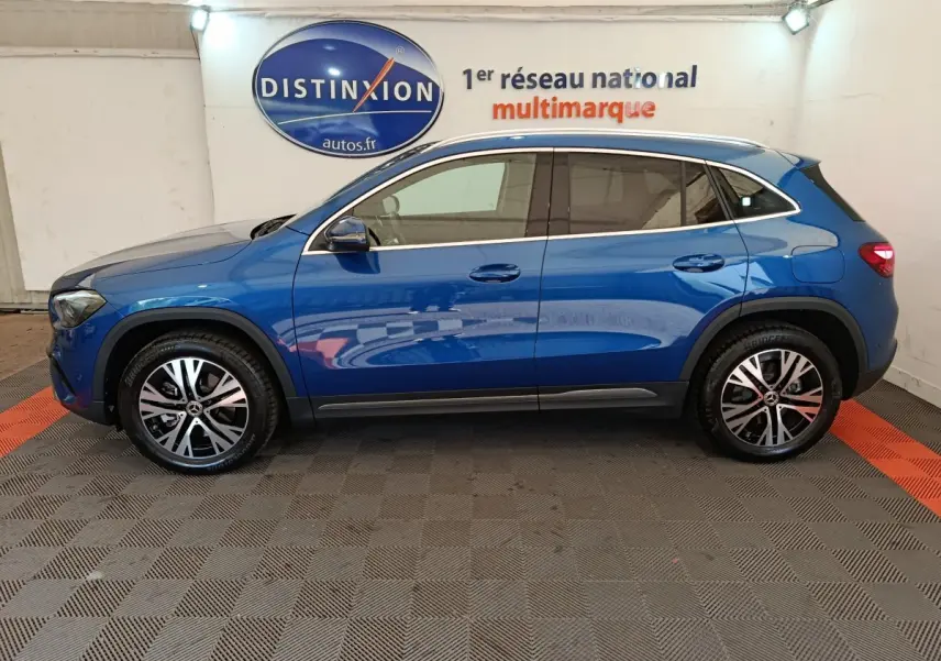 Vue de profil côté gauche d'un Mercedes GLA 250 e Business Line bleu 2024 avec jantes alliage et vitres teintées.