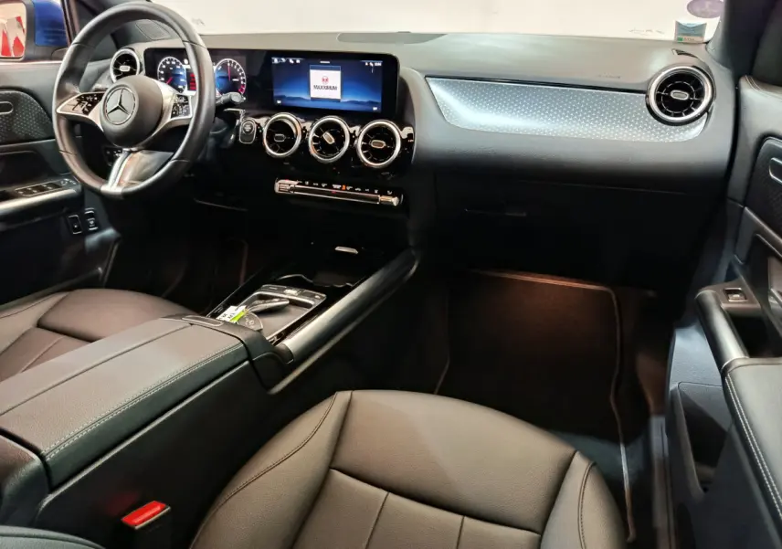 Intérieur noir du Mercedes GLA 250 e Business Line 2024, vue côté conducteur sur tableau de bord et volant cuir multifonctions.