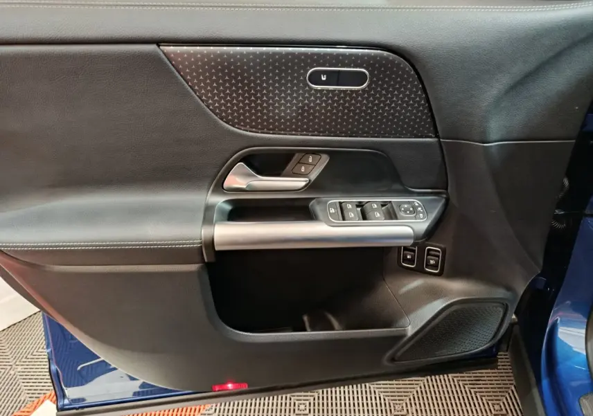 Porte intérieure côté gauche du Mercedes GLA 250 e Business Line 2024 en bleu, avec commandes fenêtres et verrouillage.