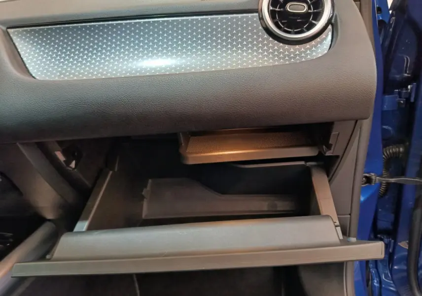 Gant de boîte à gants ouvert côté passager du Mercedes GLA 250 e Business Line bleu 2024, intérieur noir.