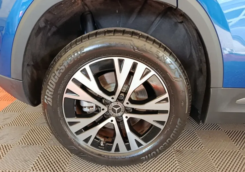 Gros plan sur la roue avant droite d'un Mercedes GLA 250 e Business Line bleu, avec jante alliage et pneu Bridgestone.