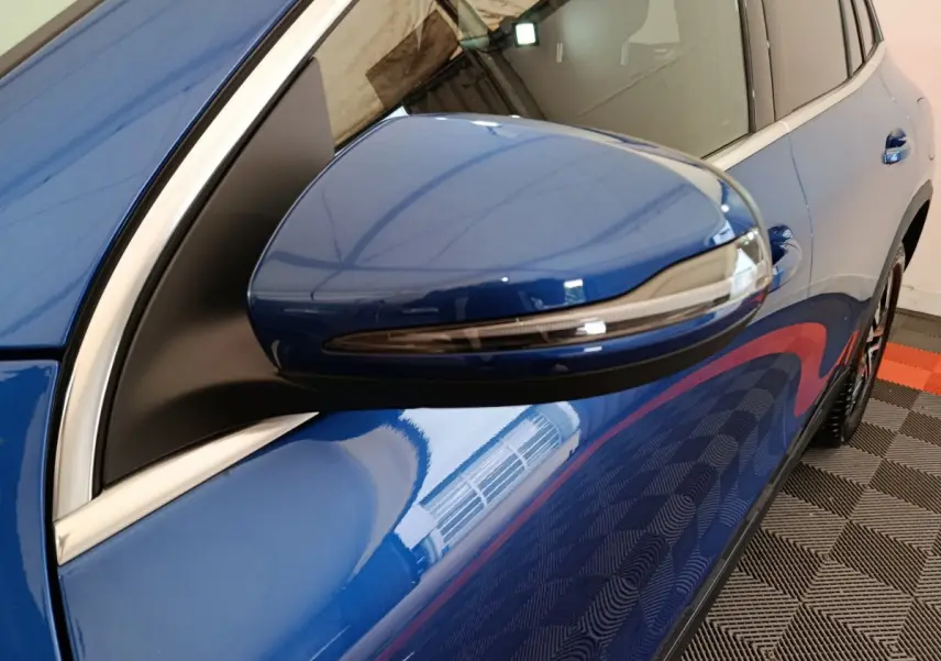 Rétroviseur droit bleu brillant du Mercedes GLA 250 e Business Line 2024 avec clignotant intégré, vue rapprochée côté passager.
