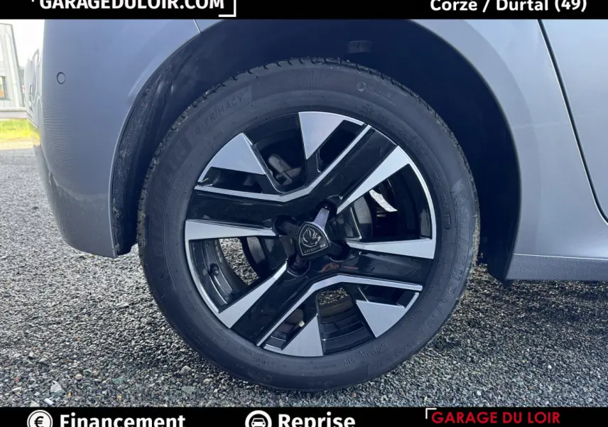 Gros plan sur la roue avant droite gris clair de la Peugeot 208 Hybrid 110 e-DCS6 Allure avec jante noire et argent.