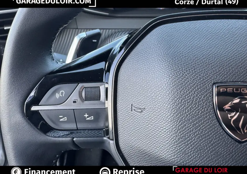 Gros plan sur le volant cuir noir de la Peugeot 208 Hybrid 110 e-DCS6 Allure avec commandes multifonctions à gauche.