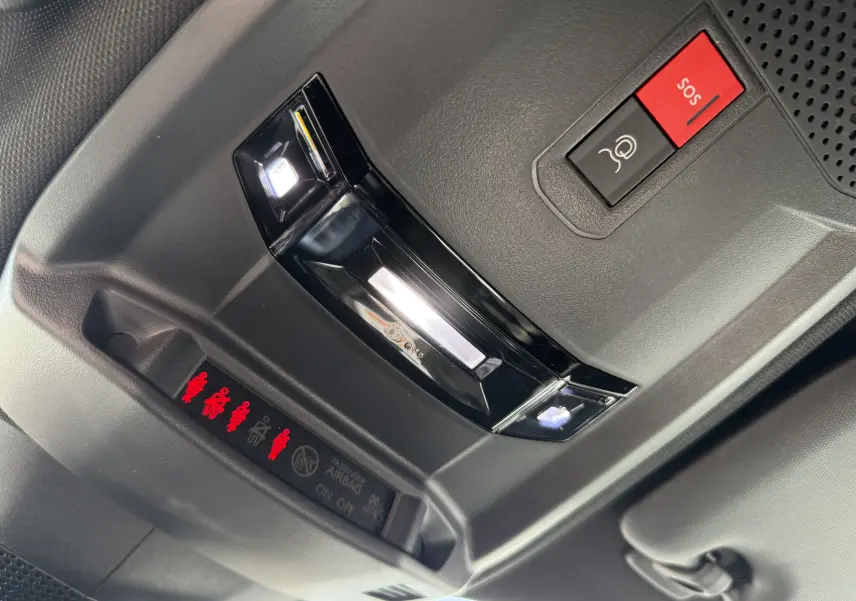 Vue intérieure en gros plan du plafonnier gris avec boutons SOS et éclairage LED du Peugeot 2008 Hybrid 145ch GT 2025.