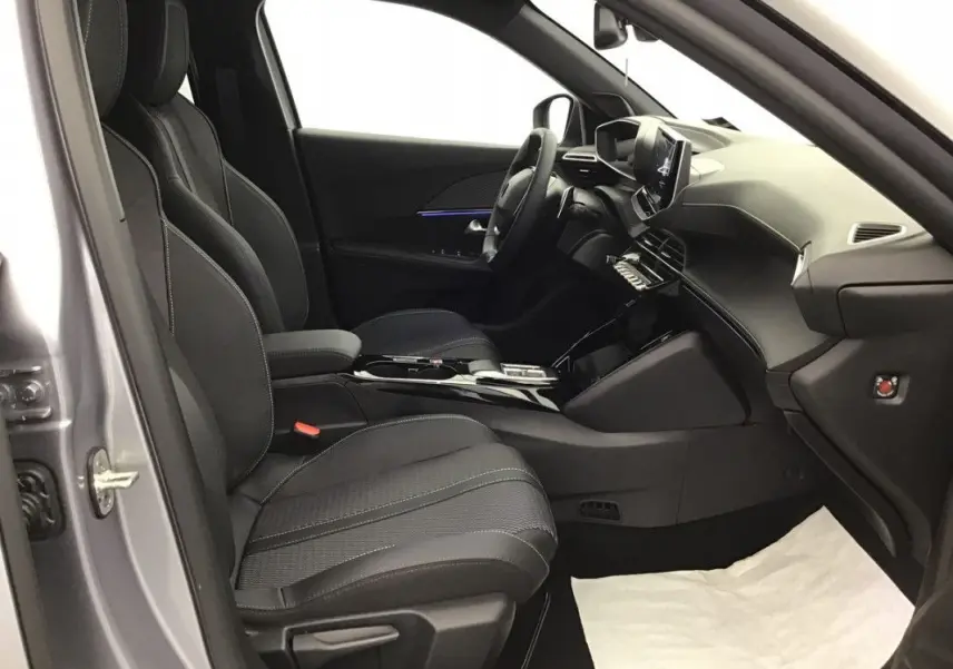 Vue intérieure côté conducteur du Peugeot 2008 Hybrid 145ch GT 2025, sièges noirs et tableau de bord moderne.