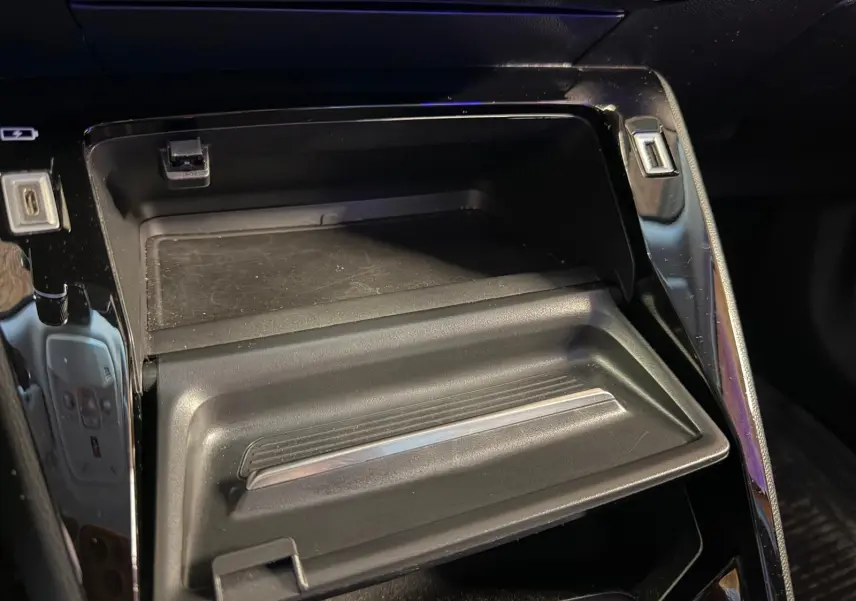 Gros plan sur la console centrale noire brillante du Peugeot 2008 1.5 BlueHDi 100 Allure 2020, avec rangement ouvert.