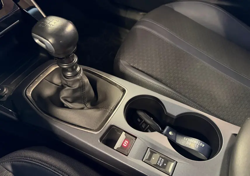 Gros plan sur la console centrale de la Peugeot 2008 2020 avec levier de vitesse manuel et porte-gobelets.