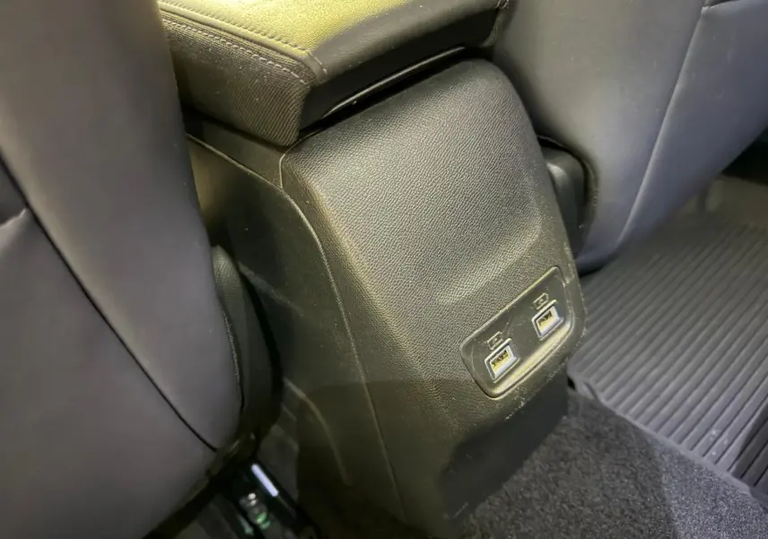 Prise USB double arrière sur console centrale noire entre sièges arrière d’une Peugeot 2008 1.5 BlueHDi 2020.