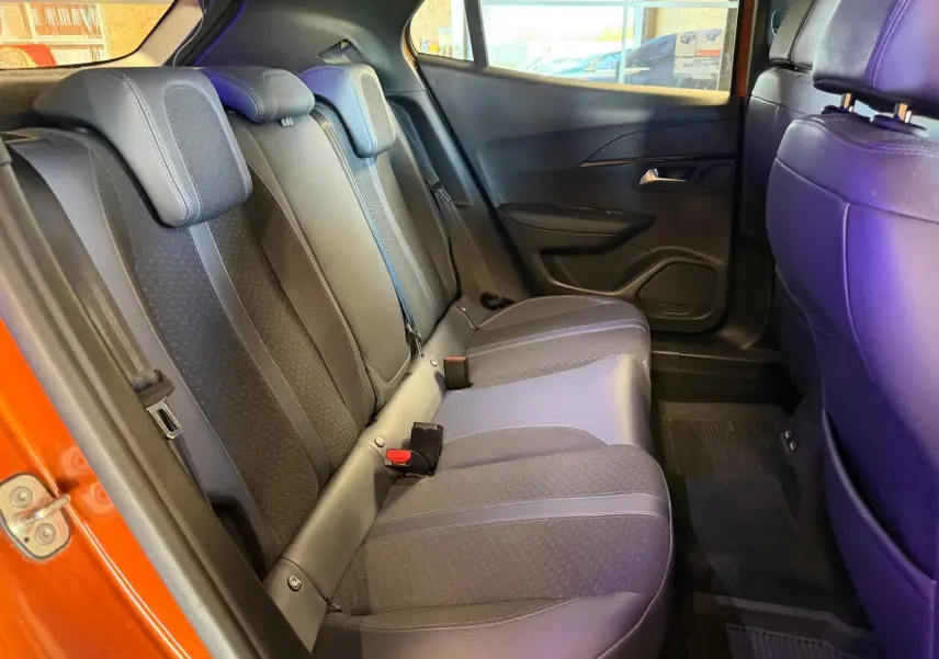Vue intérieure de la banquette arrière du Peugeot 2008 orange, avec sellerie tissu et cuir gris foncé.