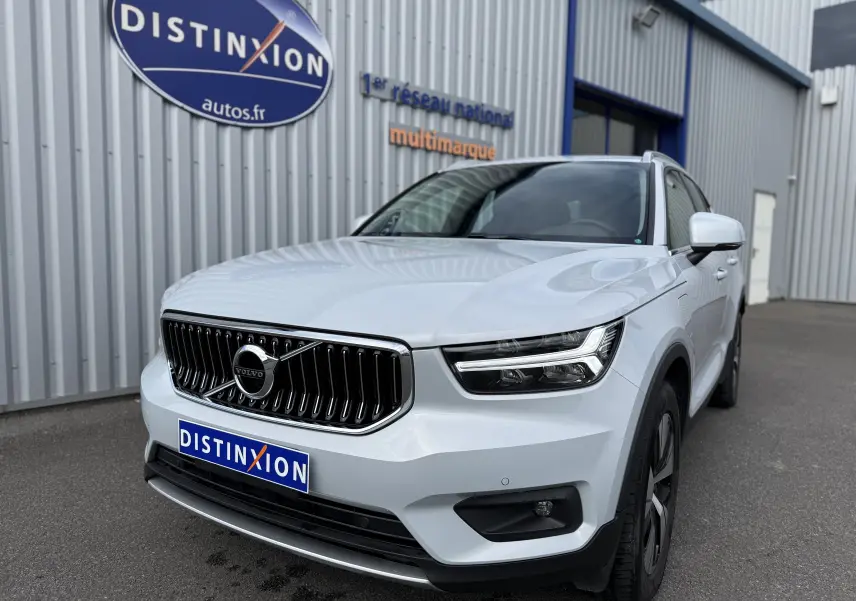 Vue 3/4 avant droite d'un Volvo XC40 blanc crystal metal, avec calandre verticale et phares LED distinctifs.