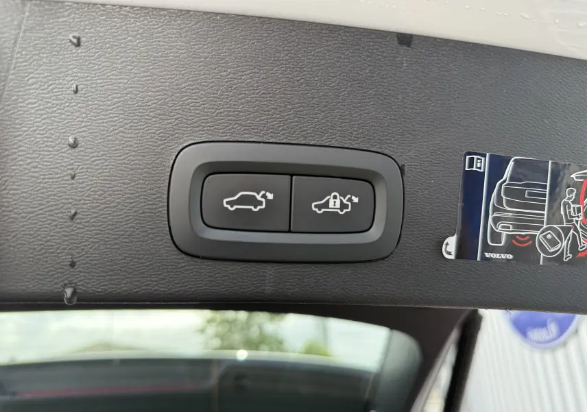 Boutons de commande d'ouverture et de verrouillage du hayon sur le bord intérieur d'un Volvo XC40 blanc Crystal Metal.