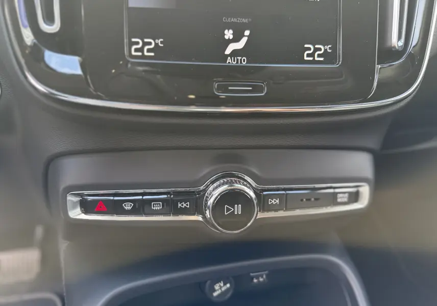 Vue rapprochée de la console centrale du Volvo XC40 blanc, montrant les commandes multimédia et climatisation à 22°C.
