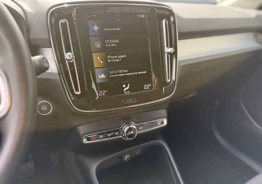Vue intérieure du tableau de bord du Volvo XC40 hybride rechargeable, avec écran tactile central et commandes climatisation visibles.