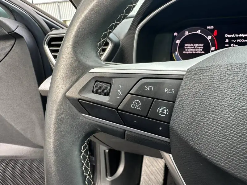 Gros plan sur les commandes multifonctions du volant cuir noir de la SEAT LEON 2.0 TDI 115ch Style XL 2025.