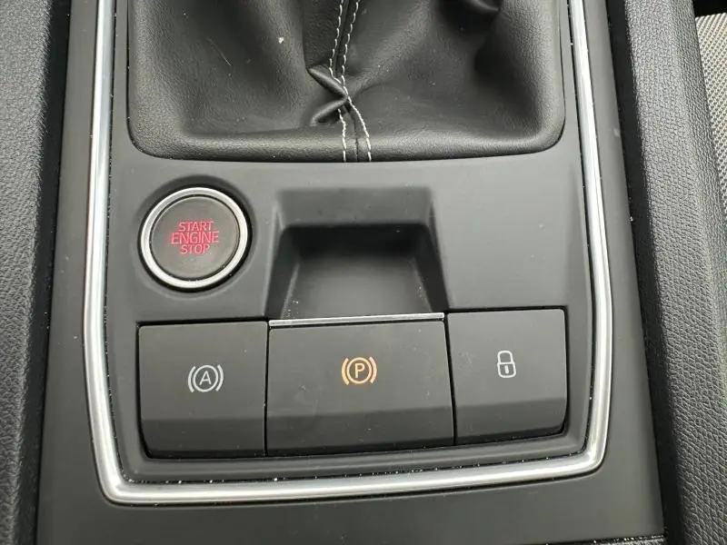 Gros plan sur la console centrale noire du SEAT LEON 2025, montrant le bouton start/stop et commandes électroniques.