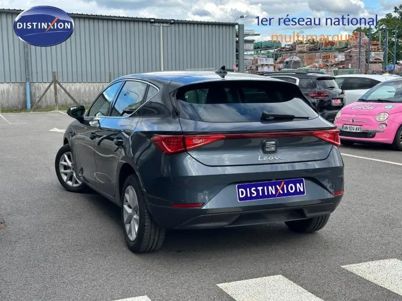 Vue 3/4 arrière droite d'une SEAT Leon 2025 noir minuit métallisée, feux arrière LED et jantes alu visibles.