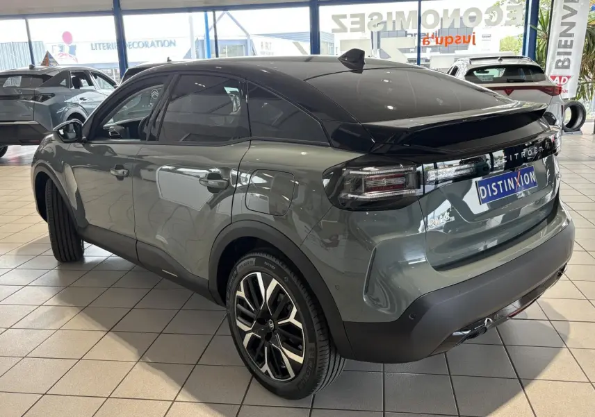 Citroën C4 hybride vert Manhattan, vue 3/4 arrière droit, toit noir Perla Nera et jantes alliage 18 pouces.