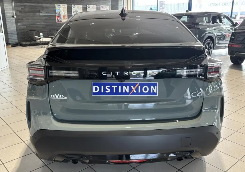 Vue arrière d'une Citroën C4 hybride 2026 vert Manhattan avec toit noir et feux arrière LED distinctifs.
