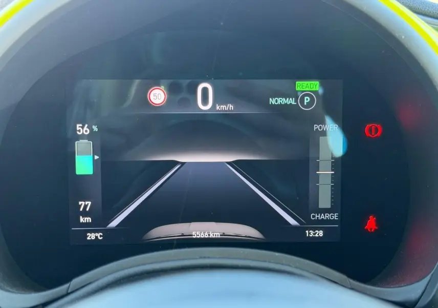 Vue rapprochée du tableau de bord numérique de la Fiat 500 e 95ch Ocean Green, affichant l'autonomie et la vitesse à 0 km/h.