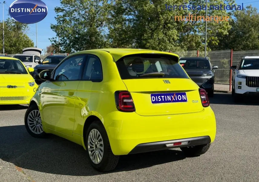 Vue 3/4 arrière droite de la FIAT 500 électrique 2024 en Ocean Green métal, avec feux arrière LED et becquet.